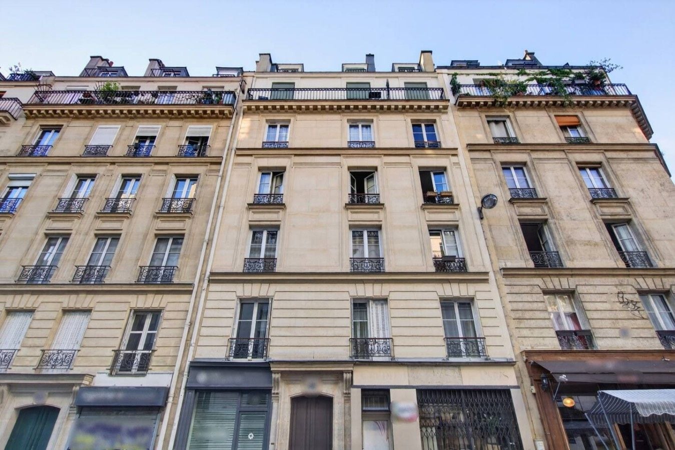 A multi-story building with a classical architectural style, featuring balconies and large windows.