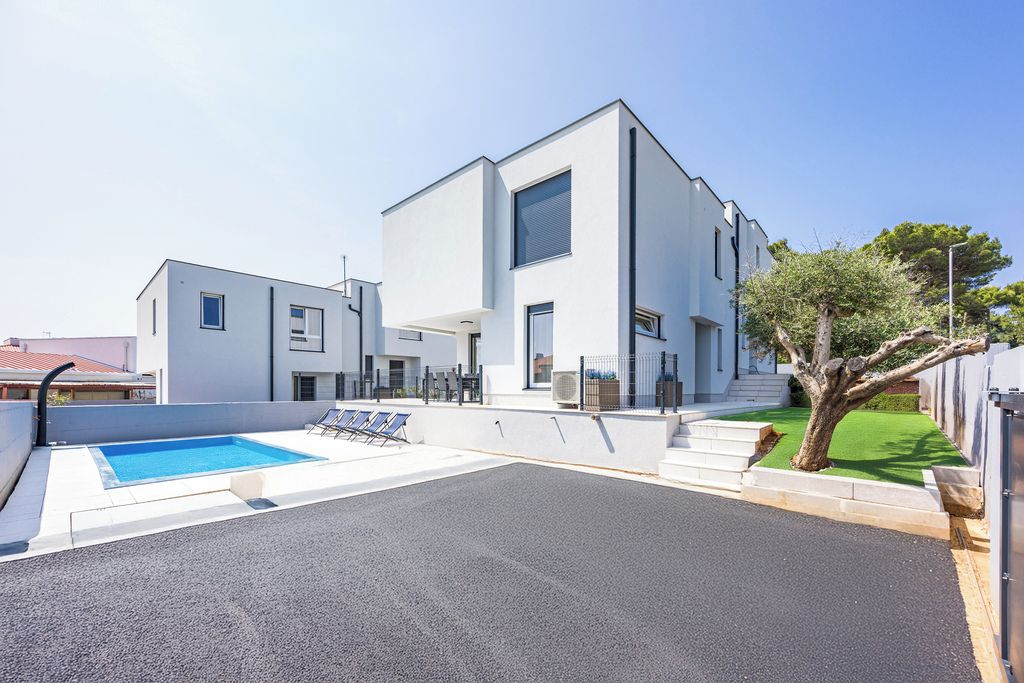 Un edificio moderno con piscina y zona de estar al aire libre.