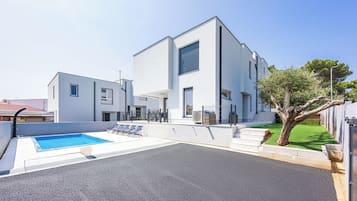 Un edificio moderno con piscina y zona de estar al aire libre.