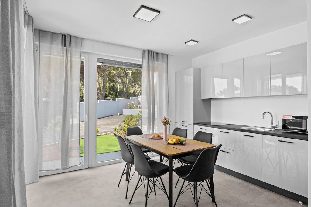 Una cocina moderna con comedor, ventanas amplias y vistas al exterior.