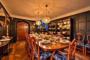 A formal dining room with a wooden table set for a meal, surrounded by upholstered chairs. - Grenville House (Kilkhampton)