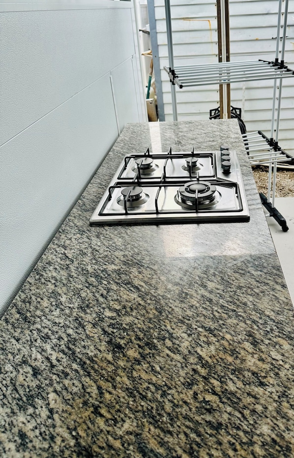 A kitchen with a granite countertop and a gas stove. - Piece of Paradise (Key largo)