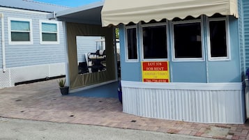 A small, single-story building with a sign indicating it is for rent.