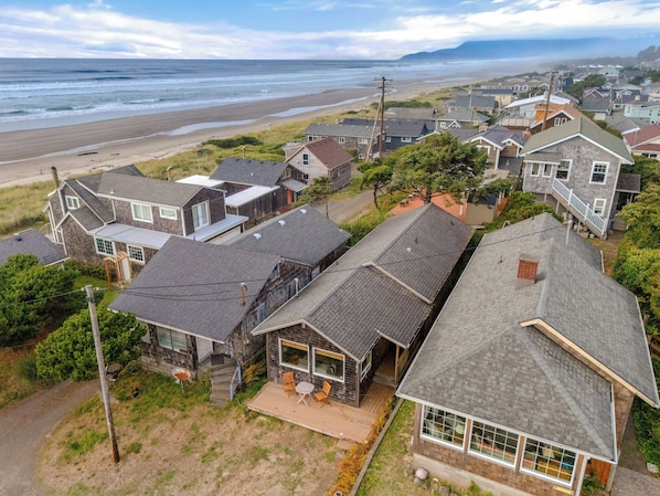 A coastal residential area with houses, a beach, and a view of the ocean.