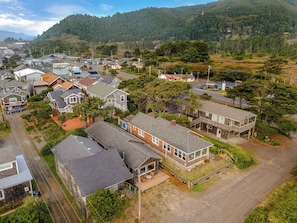 A residential area with houses, a road, and a forested hill in the background.