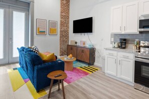 A modern kitchen with white cabinets, a built-in oven, and a microwave. - Lux Executive Suite: Sleeps 4; Heart of Columbus (Columbus)