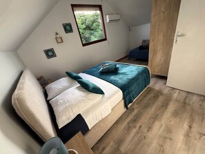 Une chambre à coucher avec un lit, une fenêtre et une porte.