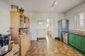A kitchen with wooden cabinets, a stainless steel refrigerator, and a tiled floor. - Holiday Home 'Casa Arrels' with Montseny Views (Sant Julià d'Alfou)