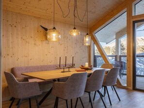 A wooden interior with a long table, six chairs, and pendant lights. - Superior Chalet # 6 With Sauna & Hot Tub (Stadl-Predlitz)