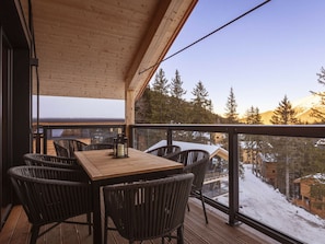 A wooden deck with a table and chairs, overlooking a snowy landscape with trees and buildings. - Superior Chalet # 6 With Sauna & Hot Tub (Stadl-Predlitz)