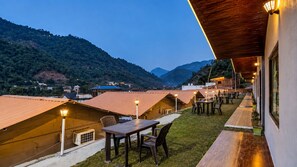 Um hotel com vários quartos, área externa para sentar e vista para as montanhas.