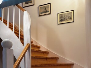 A staircase with wooden steps and white balusters, leading to a landing with framed artwork on the wall. - Det Danske Hus - Apartment Upper Deck (Dunsum)