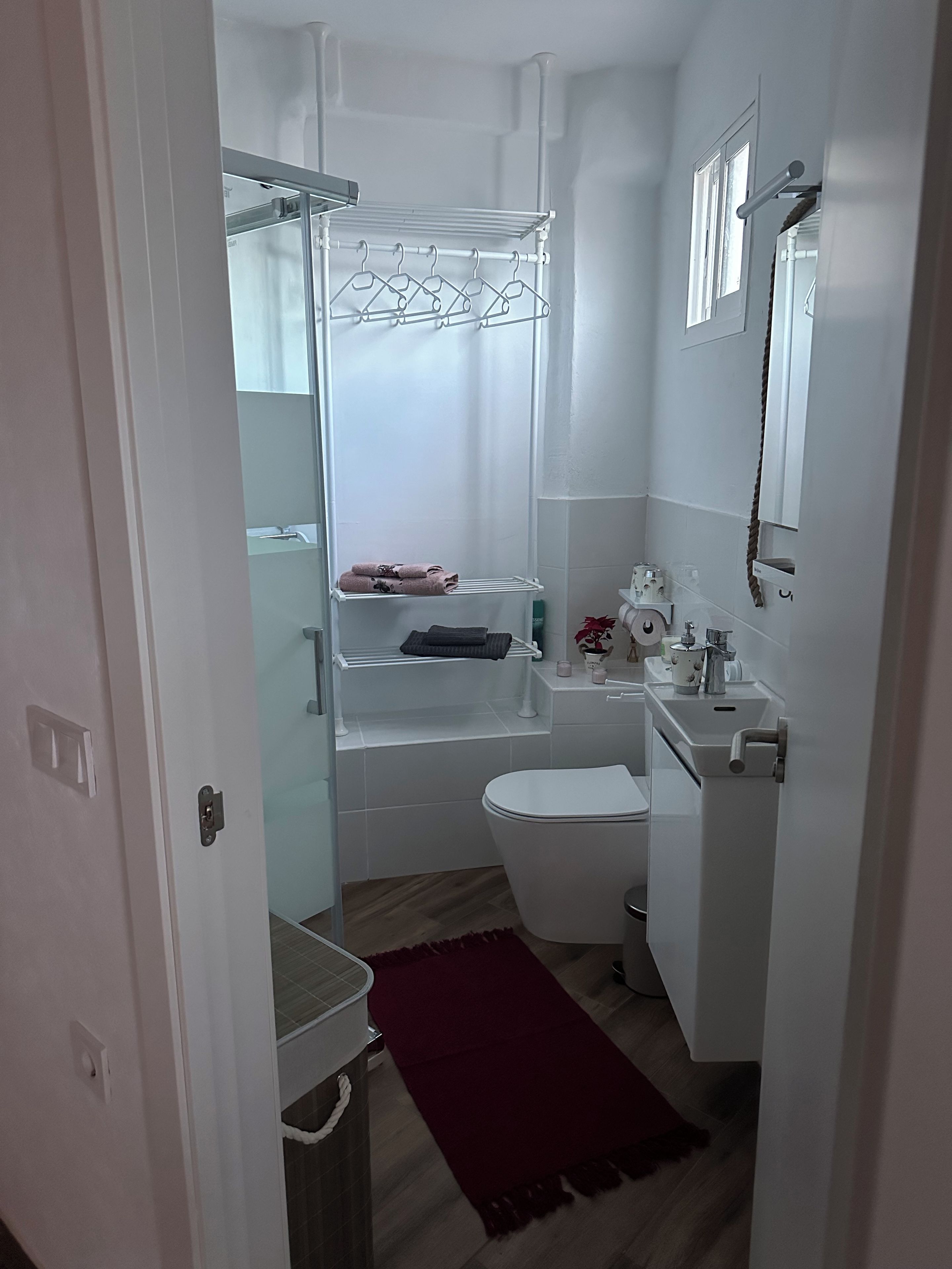 Een kleine badkamer met douche, toilet en een wastafel.