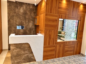 A modern bathroom with a marble countertop, wooden paneling, and a large window with a view. - S.G.P - Premium Dormitory  (Mathura)