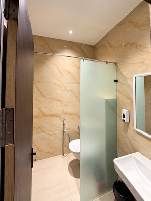 A bathroom with a glass shower enclosure, a sink, and a mirror. - S.G.P - Premium Dormitory  (Mathura)