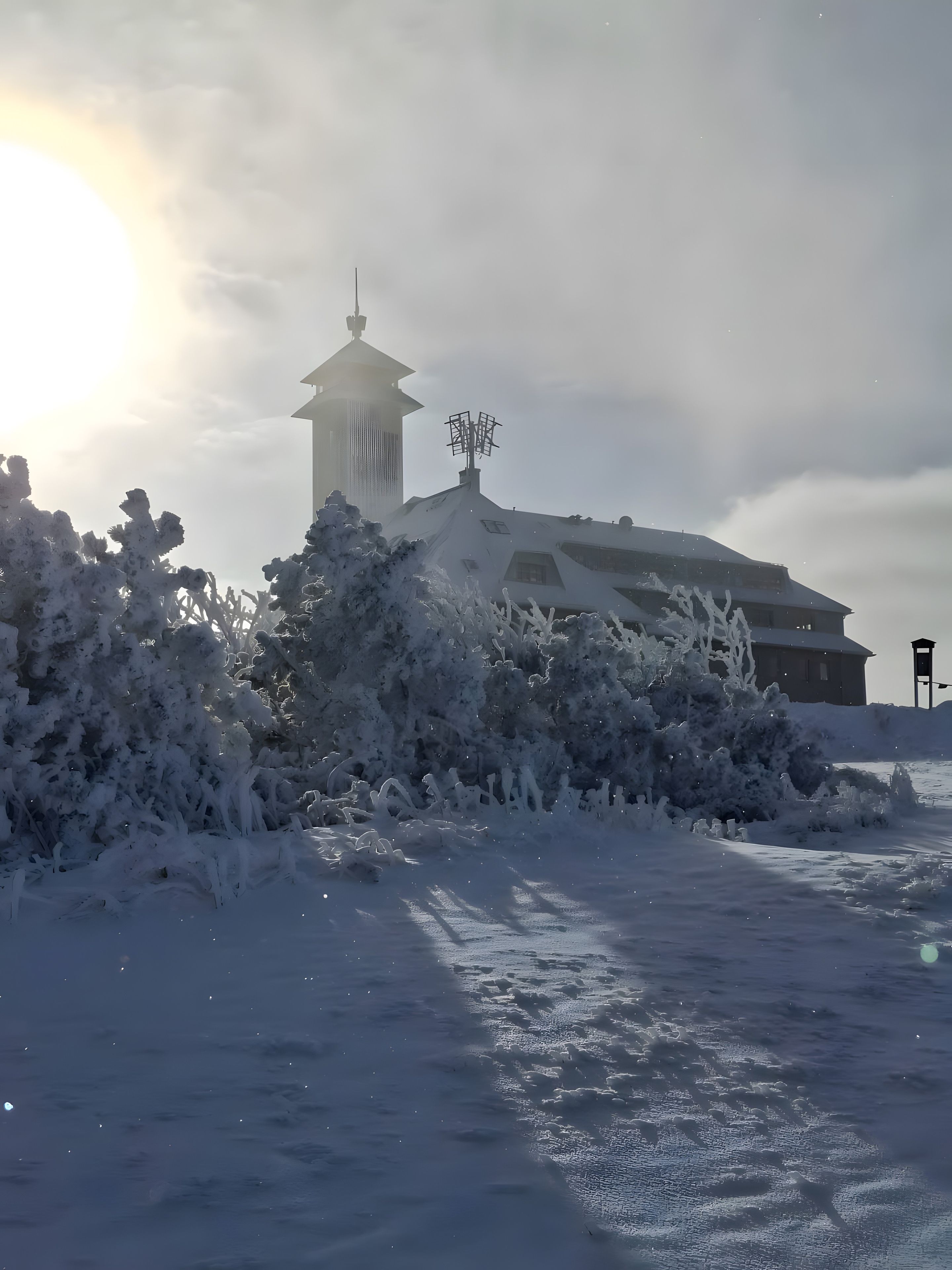 Un paisaje nevado con un edificio y una torre.