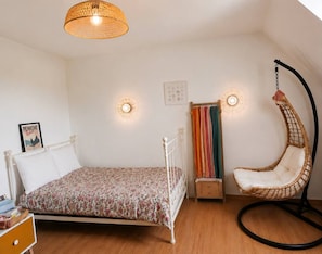 A bedroom with a bed, a hanging chair, a bedside table, and a wall-mounted lamp. - 6 bedrooms • Perfect for Christmas near Nantes (Vertou)