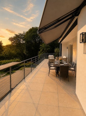 An outdoor patio with a dining table and chairs, a metal railing, and a view of trees and sky. - 6 bedrooms • Perfect for Christmas near Nantes (Vertou)