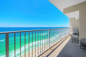 A balcony with a view of the ocean, a railing, and a few chairs. - 🌊 Tidewater 2110 🏖️ Beach Front | 🌅 Private Balcony | 🏊 Pools 🏖️ (Panama City Beach)
