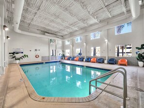 An indoor swimming pool with clear blue water, surrounded by lounge chairs and a tiled floor. - 🌊 Tidewater 2110 🏖️ Beach Front | 🌅 Private Balcony | 🏊 Pools 🏖️ (Panama City Beach)