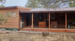 A rustic log cabin with a porch, a wooden bench, and a table with chairs. - Milner Pass Cabin/ Cozy Mountain retreat in South Fork, CO (Alpine)