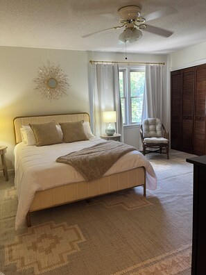 A bedroom with a bed, a chair, a window with curtains, a ceiling fan, and a wardrobe. - Fantastic 2-bedroom townhome in North Charleston (North Charleston)