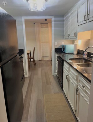 A kitchen with a refrigerator, microwave, sink, and cabinets. - Fantastic 2-bedroom townhome in North Charleston (North Charleston)