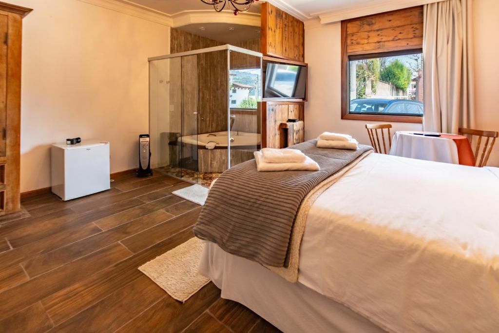 Ein Hotelzimmer mit Bett, Fernseher, Dusche und Blick nach draußen.