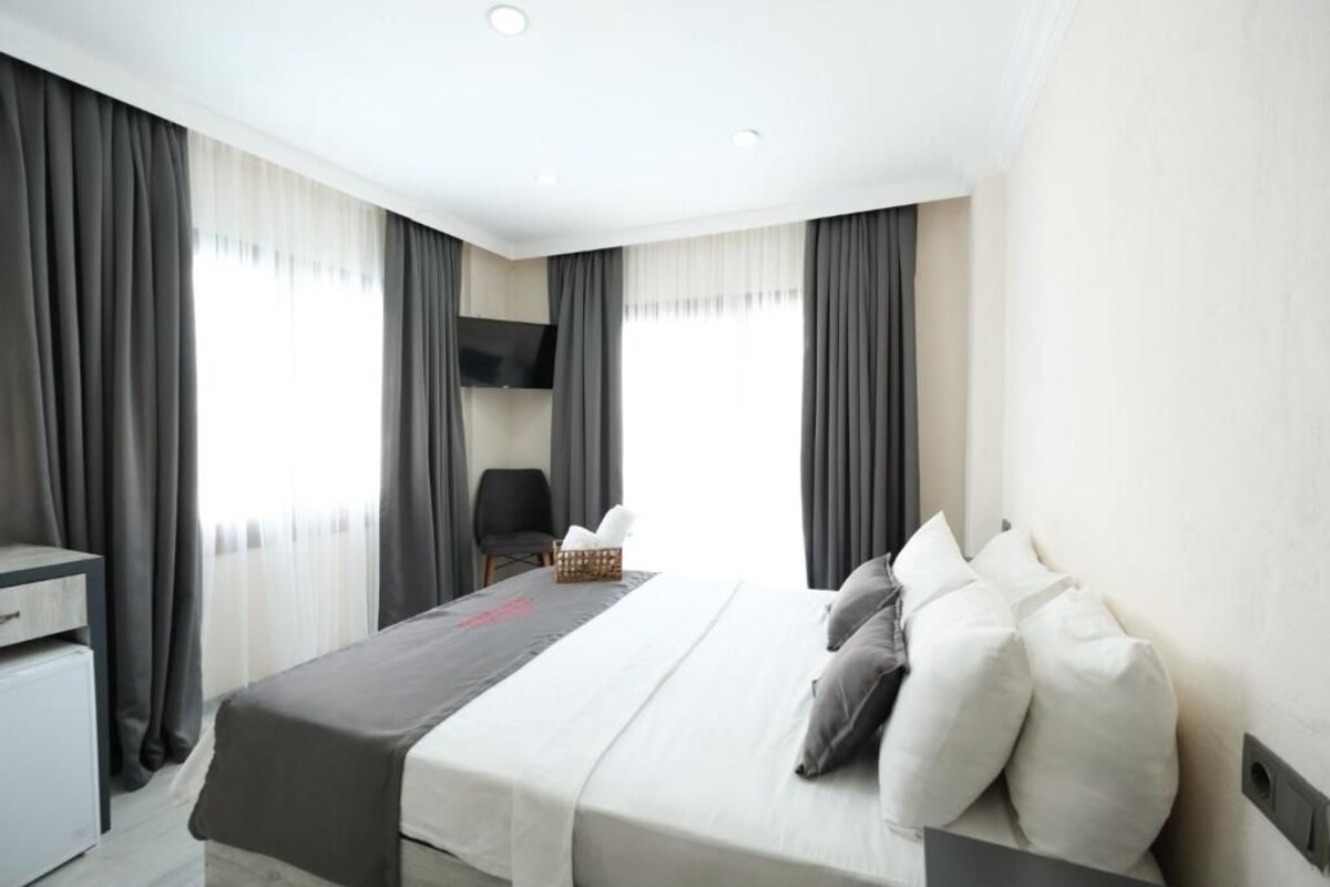 A hotel room with a bed, a desk, and a chair.