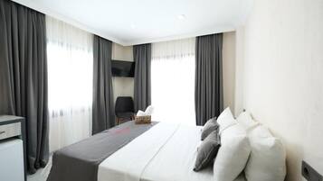 Una habitación de hotel con una cama, un escritorio y una silla.