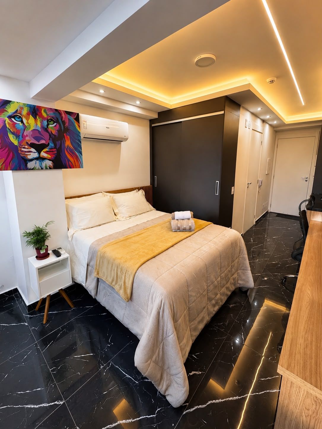 Une chambre d’hôtel moderne, équipée d’un lit, d’une table de chevet et d’un tableau au mur.