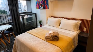 Una habitación de hotel con cama, escritorio y vistas a la ciudad.