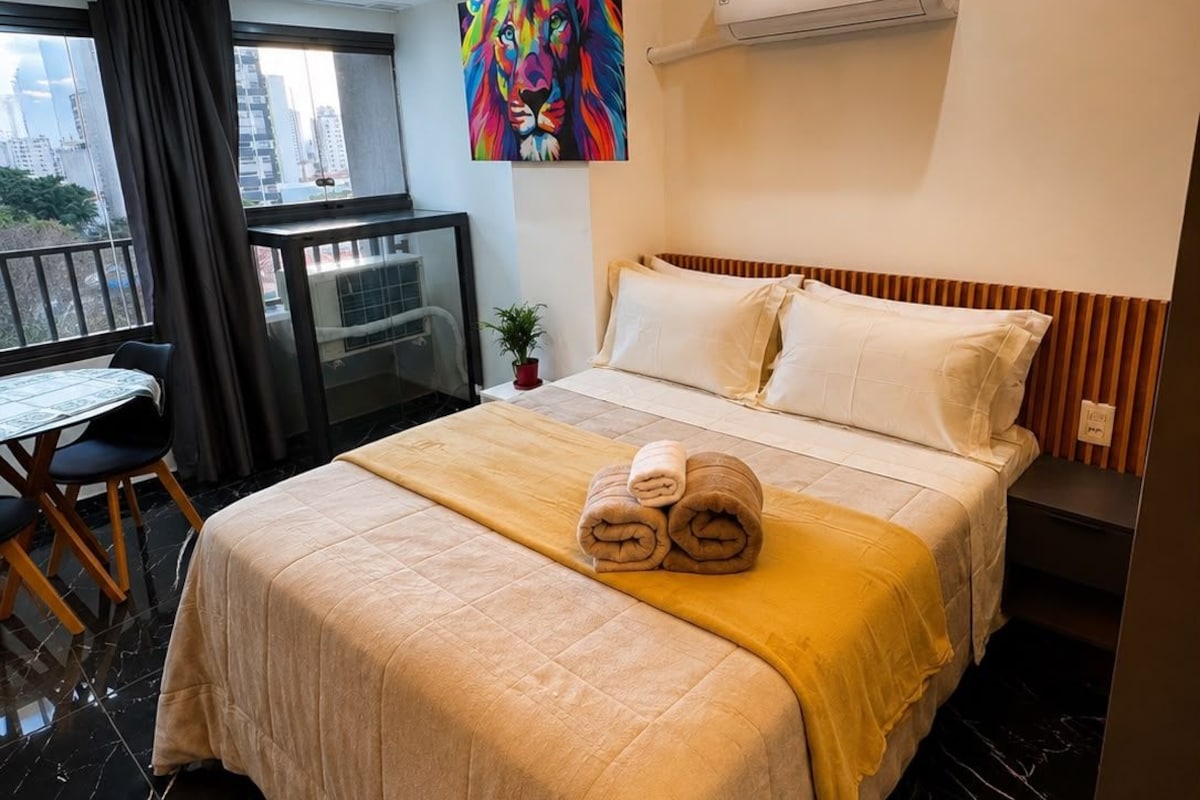 Una habitación de hotel con cama, escritorio y vistas a la ciudad.