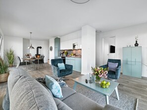 A modern living room with a sofa, two armchairs, a coffee table, and a dining area with a table and chairs. - Apartment in Kappeln With Swimming Pool (Kappeln)