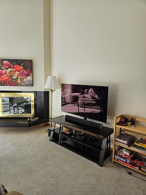 A living room with a flat-screen TV, a fireplace, a bookshelf, and a painting on the wall. - SHE306 Fabulous 1 bedroom + loft by the Super Bee Lift, makes a vacation perfect (Frisco)