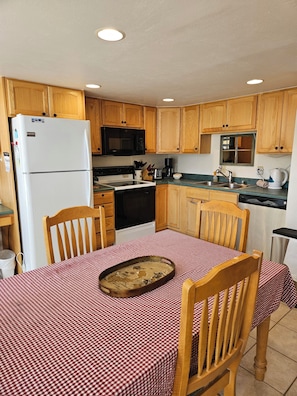 A compact kitchen with wooden cabinets, a white refrigerator, a microwave, a stove, and a sink. - SHE306 Fabulous 1 bedroom + loft by the Super Bee Lift, makes a vacation perfect (Frisco)
