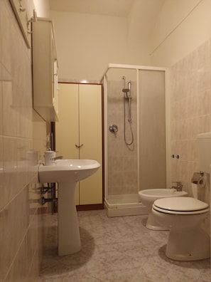 Un baño con lavabo, inodoro, bidé y cabina de ducha.