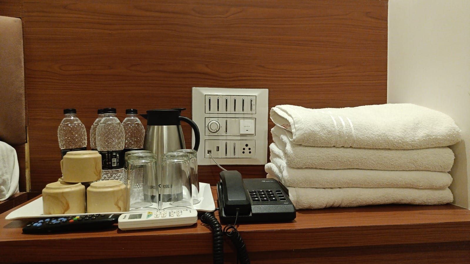 A hotel reception desk with a telephone, a scale, a coffee maker, and toiletries.
