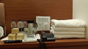 A hotel reception desk with a telephone, a scale, a coffee maker, and toiletries.