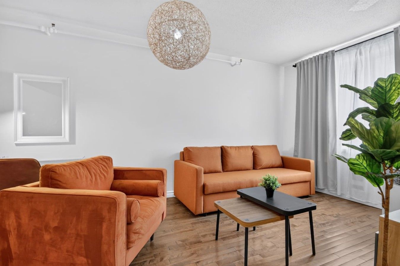 A modern living room with a sofa, armchair, and a coffee table.