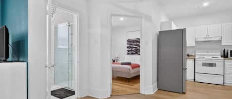 A modern apartment with a kitchen, a bedroom, and a living area.