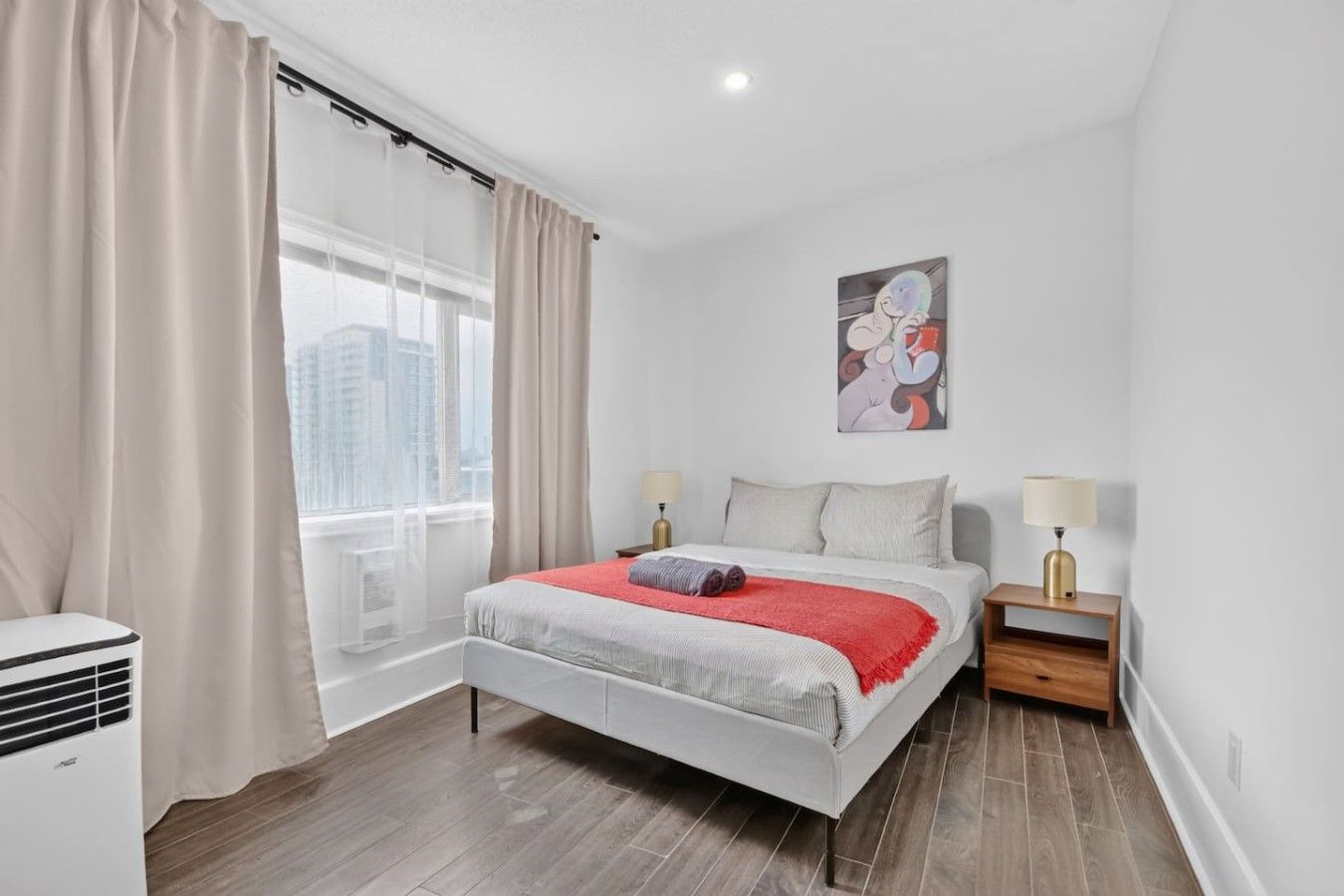 Une chambre d’hôtel moderne équipée d’un lit, de tables de chevet, d’une fenêtre avec des rideaux et offrant une vue sur la ville.