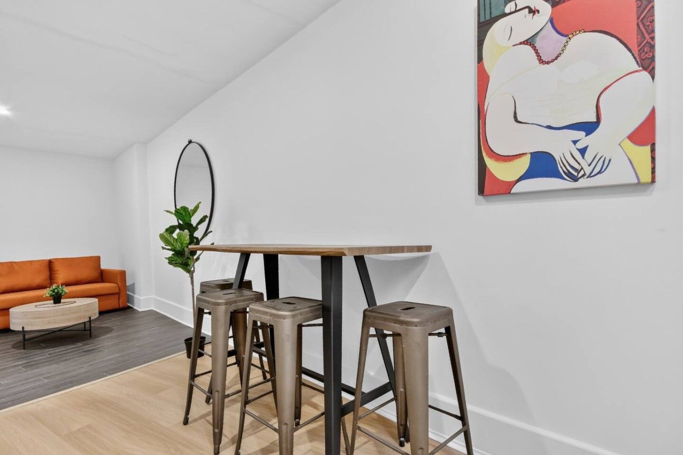 Een modern interieur met een bank, een klein tafeltje en twee krukken.
