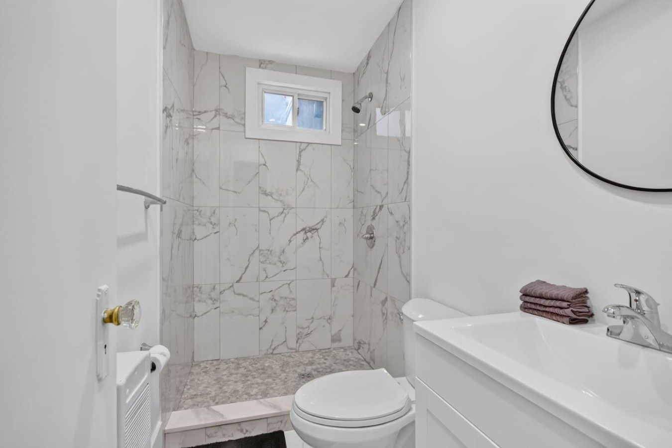 A bathroom with a shower, toilet, and sink.
