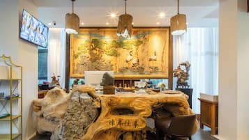 Ein Essbereich mit einem Holztisch, Stühlen und einer Wand mit Dekorationen und Kunstwerken.