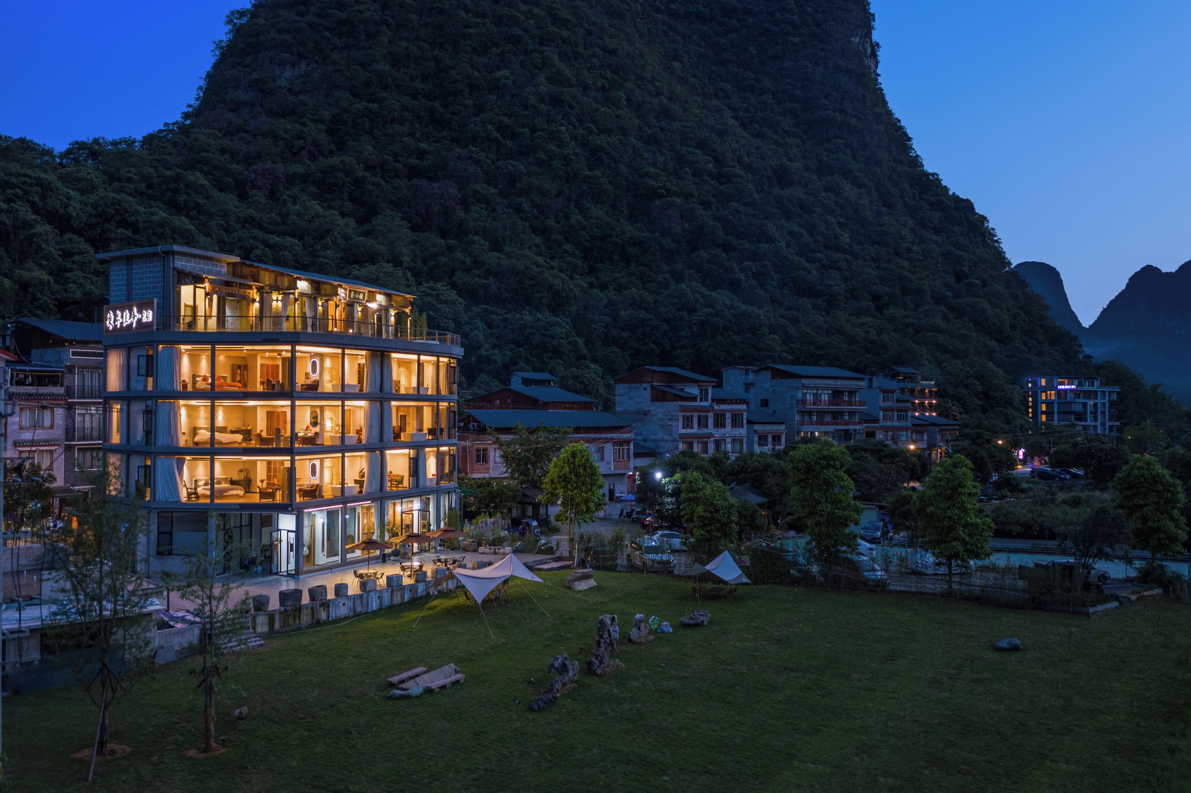 Un hotel moderno de varios pisos, ubicado en una zona montañosa con vistas al paisaje circundante.