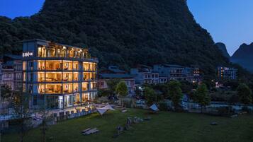 Un hotel moderno de varios pisos, ubicado en una zona montañosa con vistas al paisaje circundante.