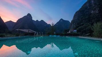 A swimming pool with clear water reflecting the surrounding mountains.