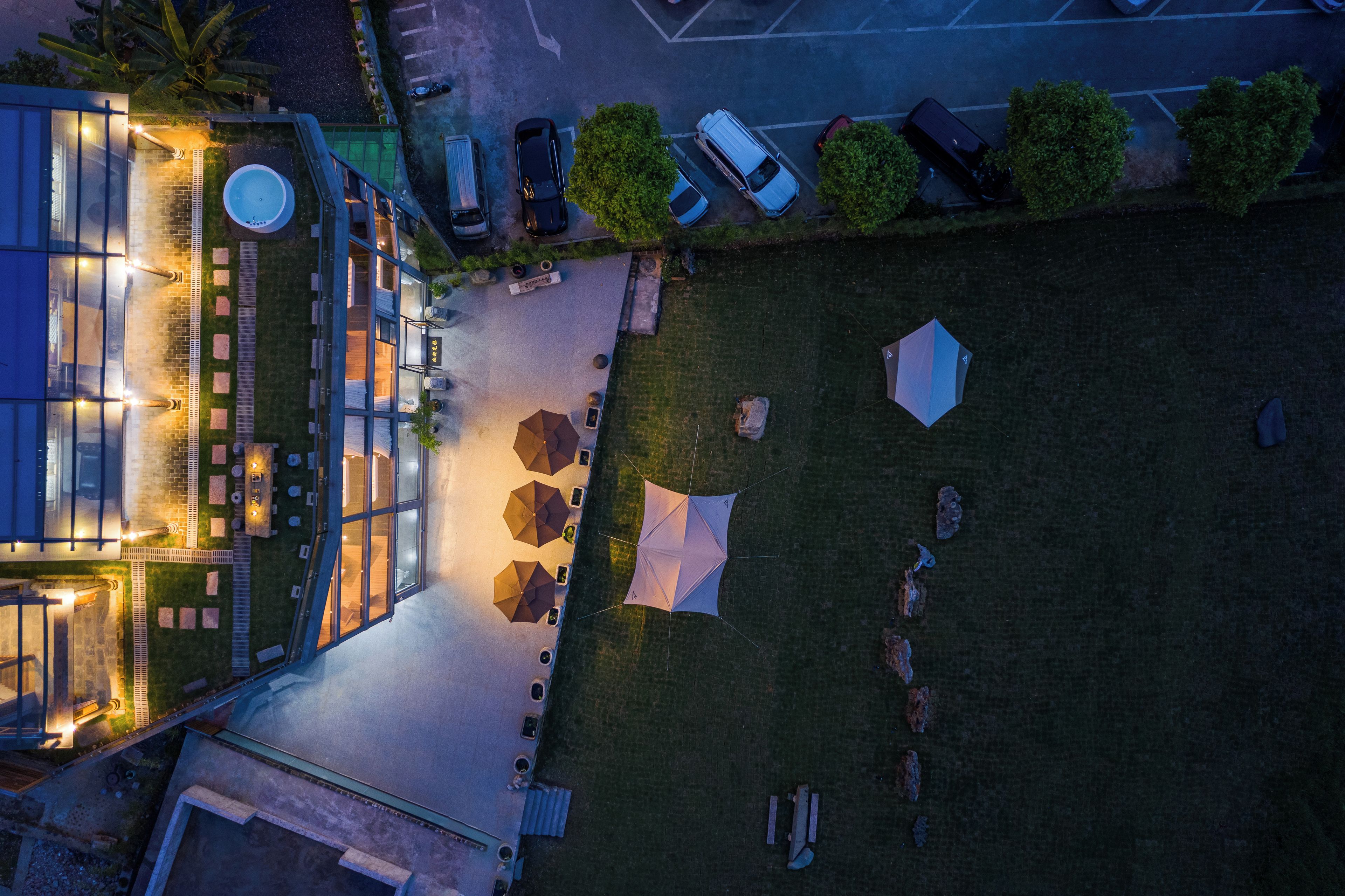 Vista aérea de un hotel con terraza, piscina y aparcamiento.