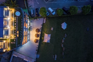 Vista aérea de un hotel con terraza, piscina y aparcamiento.